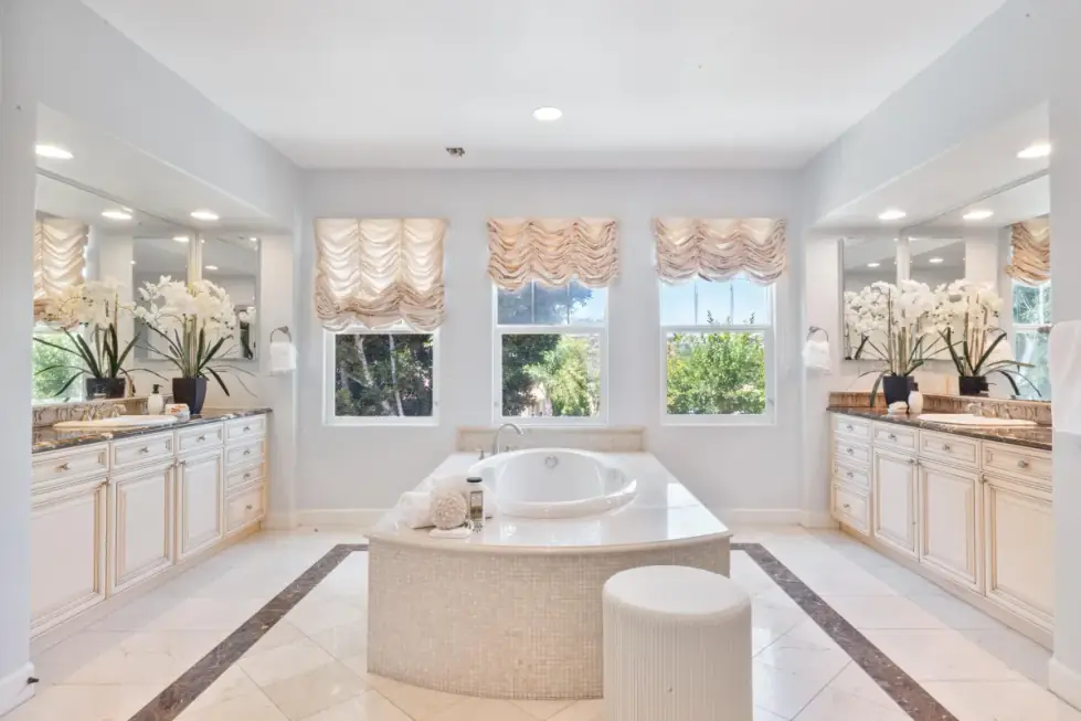 A luxury primary bathroom with a dual vanity and soaking tub, photographed with bracketed exposures