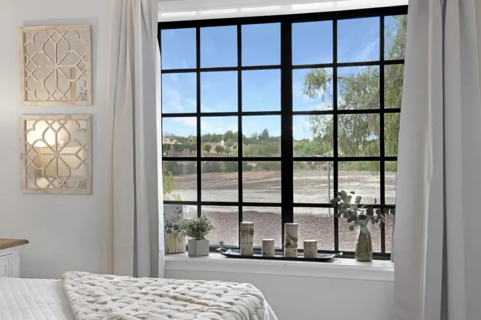 A bedroom with a large window, photographed with bracketed HDR exposures