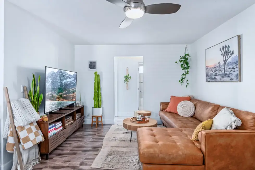A bright living room with large windows, photographed before styling